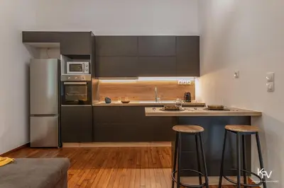 a kitchen with stainless steel appliances and wooden floors at Modern and Cozy apartment in the heart of Athens in Athens