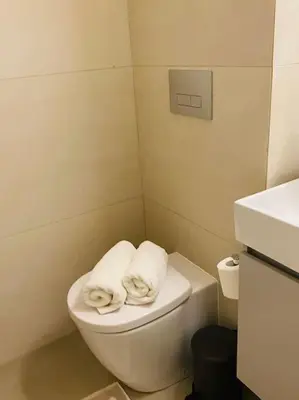a bathroom with a toilet with two towels on it at Luxury Maisonette with Shared Pool in Athens