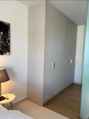 a bedroom with white walls and a bed and a table at Luxury Maisonette with Shared Pool in Athens
