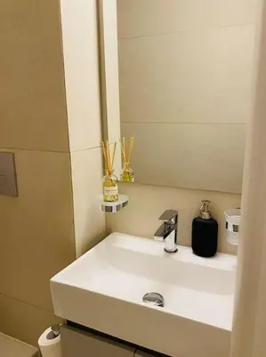 a bathroom with a white sink and a mirror at Luxury Maisonette with Shared Pool in Athens