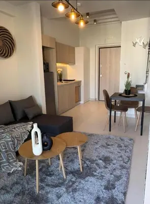 a living room with a couch and a table and a kitchen at Luxury Maisonette with Shared Pool in Athens