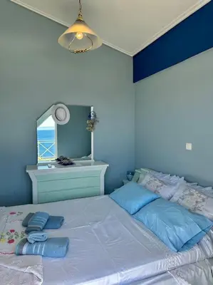 a blue bedroom with a large bed with a mirror at Summer Villa , Kaki Thalassa in Dhaskalión