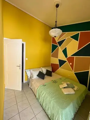 a bedroom with a bed and a colorful wall at Summer Villa , Kaki Thalassa in Dhaskalión