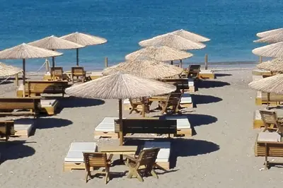 a beach with tables and chairs and umbrellas at Summer Villa , Kaki Thalassa in Dhaskalión