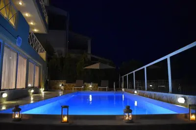 a large blue swimming pool at night with lights at Summer Villa , Kaki Thalassa in Dhaskalión