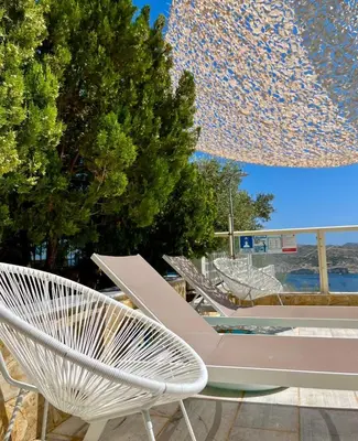 a group of white chairs sitting next to a pool at Summer Villa , Kaki Thalassa in Dhaskalión