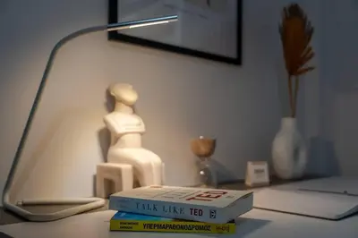 a lamp on a table with a book and a figurine at JV Luxury Apartment Acropolis in Athens