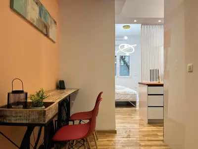 a kitchen with two red chairs and a table in a room at Cozy studio near Flisvos Marina in Athens