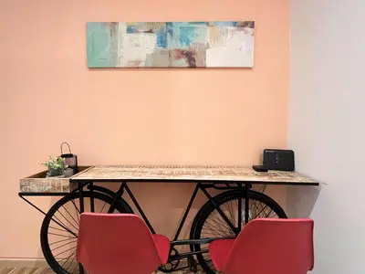 a table with two chairs and a bike against a wall at Cozy studio near Flisvos Marina in Athens