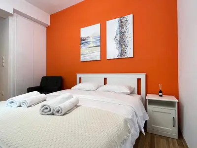 a bedroom with two beds with orange walls at Cozy studio near Flisvos Marina in Athens