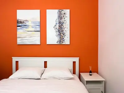 a bedroom with three paintings above a bed at Cozy studio near Flisvos Marina in Athens