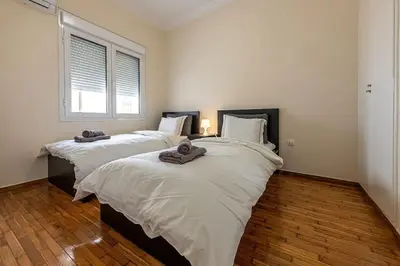 a bedroom with two beds with towels on them at kerameikos 2 bedroom apartment in Athens