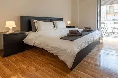 a bedroom with a large bed with two towels on it at kerameikos 2 bedroom apartment in Athens