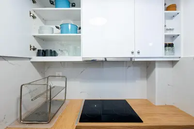 a kitchen with white cabinets and a black mat on the floor at Alex 2 Bedroom Apartment in Athens in Athens