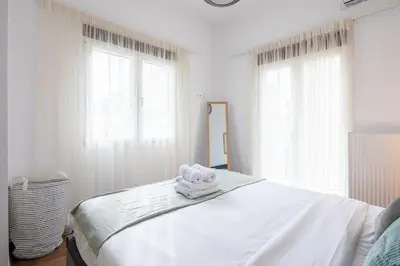a white bedroom with a bed with towels on it at Alex 2 Bedroom Apartment in Athens in Athens