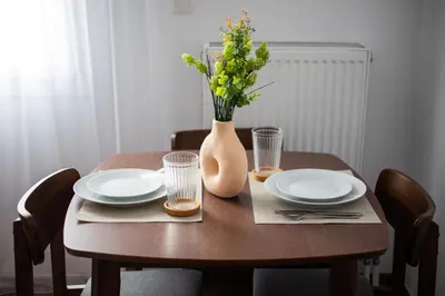 a wooden table with plates and a vase with flowers at Alex 2 Bedroom Apartment in Athens in Athens
