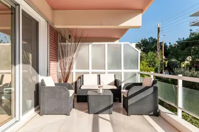 a patio with chairs and a table on a balcony at Eclipse Riviera Cinema in Athens
