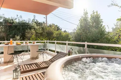 a hot tub on the deck of a house at Eclipse Riviera Cinema in Athens