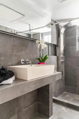 a bathroom with a sink with a vase of flowers at Eclipse Riviera Cinema in Athens