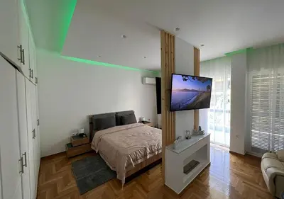 a bedroom with a bed and a flat screen tv at Sea View Studio in Athens