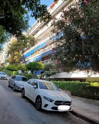 a white car parked on the side of a street at Sea View Studio in Athens