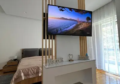 a bedroom with a flat screen tv hanging on the wall at Sea View Studio in Athens
