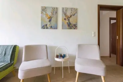 two chairs and a table in a room at Spacious 3bdr apart w/balcony-5 mins to acropolis in Athens