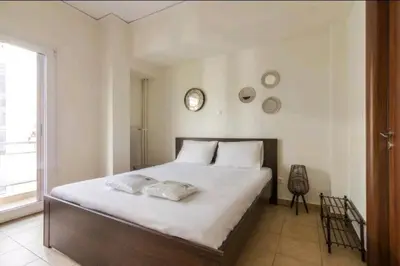 a bedroom with a large white bed with two pillows at Spacious 3bdr apart w/balcony-5 mins to acropolis in Athens