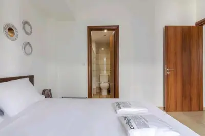 a bedroom with a white bed and a toilet at Spacious 3bdr apart w/balcony-5 mins to acropolis in Athens