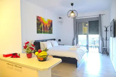 a bedroom with a bed and a table with a bowl of fruit at Seaside Bliss in Varkiza - Dreamy Balcony with Stunning Sea Views in Varkiza
