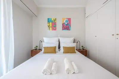 a bedroom with a white bed with two pillows at Spacious 2BDs Apt With Acropolis View In Center in Athens