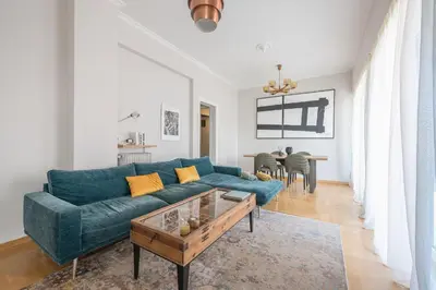 a living room with a blue couch and a table at Spacious 2BDs Apt With Acropolis View In Center in Athens