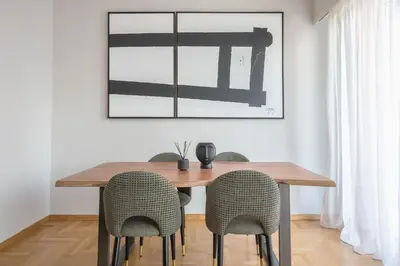 a dining room table with chairs and a picture on the wall at Spacious 2BDs Apt With Acropolis View In Center in Athens