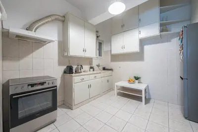 a kitchen with white cabinets and a stove top oven at Spacious 2BDs Apt With Acropolis View In Center in Athens