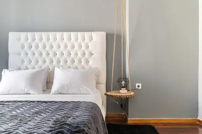 a bedroom with a white bed with a large headboard at Eclipse Glyfada Beach in Athens