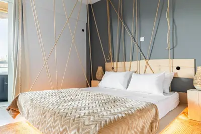 a bedroom with a king sized bed with a wooden headboard at Eclipse Glyfada Beach in Athens