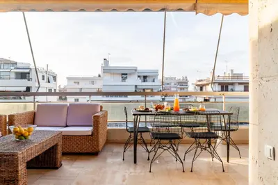 a balcony with a table and chairs and a boat at Eclipse Glyfada Beach in Athens