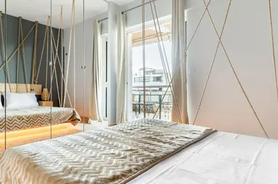a bedroom with a bed and a large window at Eclipse Glyfada Beach in Athens