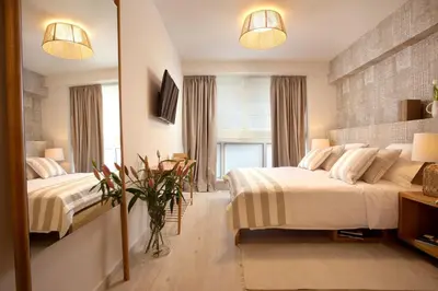 a bedroom with two beds and a mirror at Joy Luxury Central Apartment in Athens