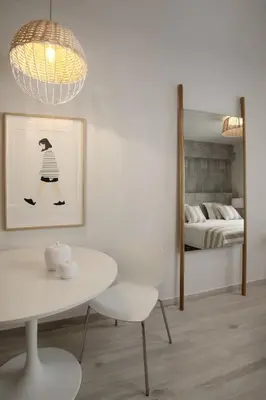 a white dining room with a table and a mirror at Joy Luxury Central Apartment in Athens