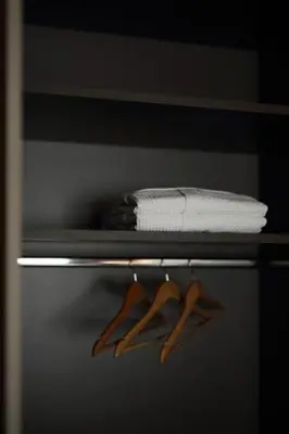 a shelf with towels and wooden hangers on it at Joy Luxury Central Apartment in Athens