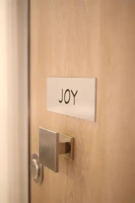 a door with a sign that says joy on it at Joy Luxury Central Apartment in Athens