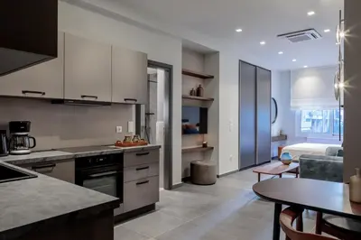 a kitchen and living room with a table and a couch at Jasmine Luxury Apartment in Athens