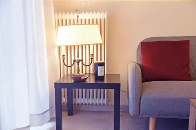 a living room with a table and a chair and a lamp at Athens Faliro Beach Residence, close to city center in Athens