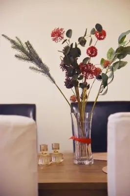 a vase with flowers in it on a table at Athens Faliro Beach Residence, close to city center in Athens