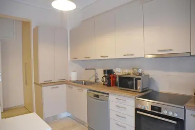 a kitchen with white cabinets and a stove top oven at Athens Faliro Beach Residence, close to city center in Athens