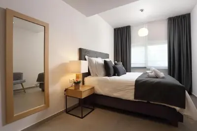 a bedroom with a large bed and a mirror at Fivos Luxury Suite in Athens