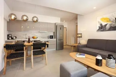 a kitchen and living room with a couch and a table at Fivos Luxury Suite in Athens