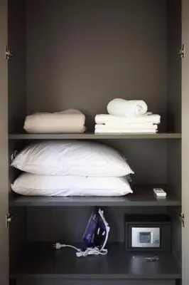 a shelf with white pillows and a microwave at Fivos Luxury Suite in Athens