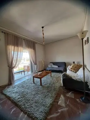 a living room with a bed and a table at Apollo Apartment Athens/Airport in Spáta